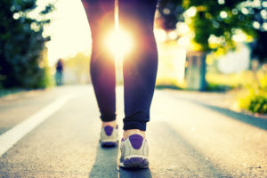 Close-up of woman athlete feet and shoes while running in park. Fitness concept and welfare with female athlete joggin in city park